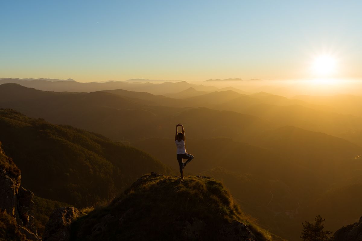 A holistic personal trainer doing yoga outside