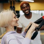 A male personal trainer and his female client in a gym