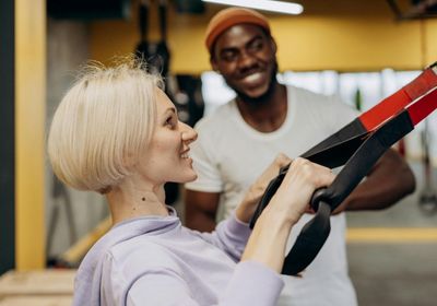 A male personal trainer and his female client in a gym
