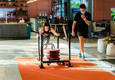 A personal trainer and a client in a gym