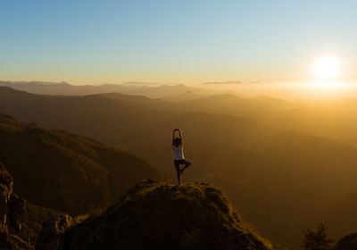 A holistic personal trainer doing yoga outside