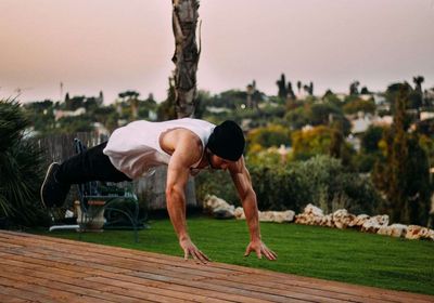 A calisthenics personal trainer doing push-ups. 