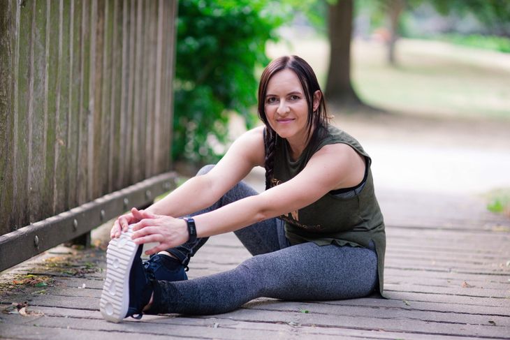 Lidia, the focus of this personal trainer story, stretching.