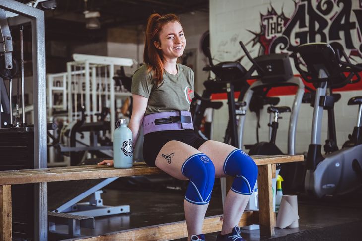 A personal trainer wearing a lifting belt