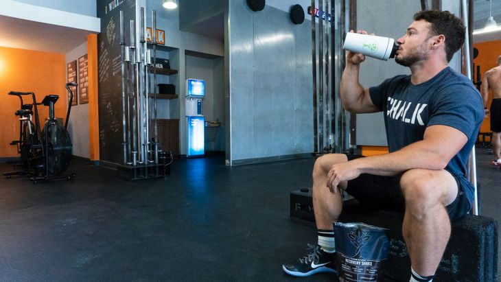 A man in a gym drinking a protein shake