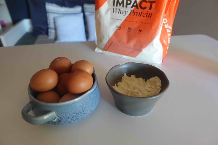 A bowl of eggs and a bowl of whey protein powder