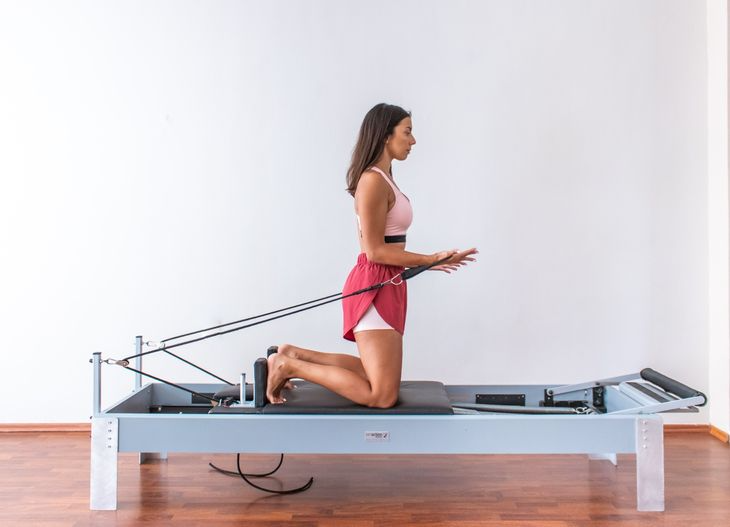 Pilates personal trainer on a reformer