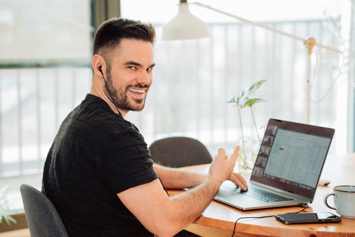 An online PT working on his laptop