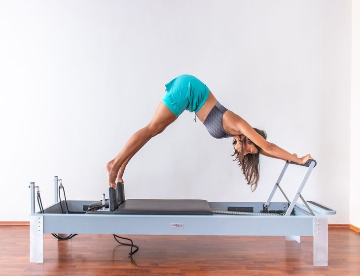 Pilates personal trainer on a reformer
