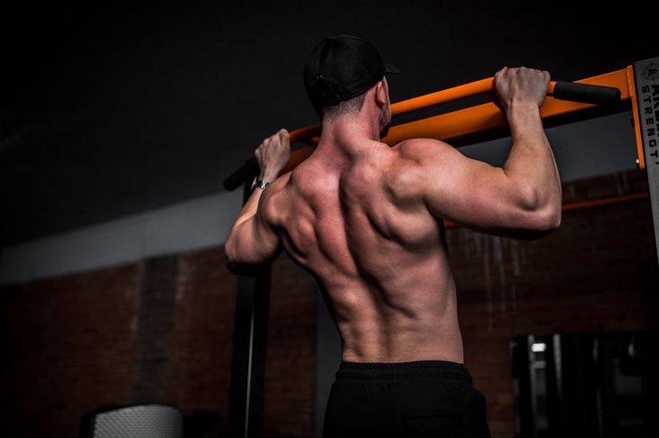 A man in a dark gym completing calisthenics exercises for beginners