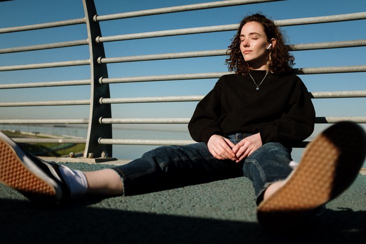 A woman listening to music, which is good for post-exercise recovery.