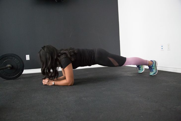 Personal trainer doing a plank as part of a total body HIIT workout.