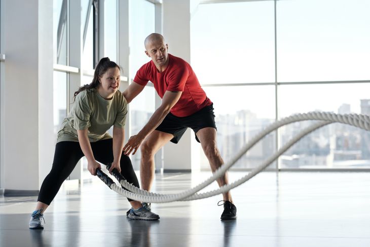 Personal trainer helping a client with form