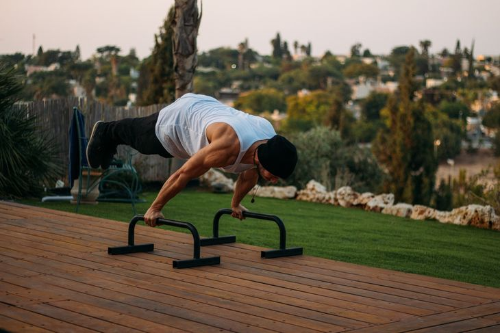 A calisthenics personal trainer on parallel bars.